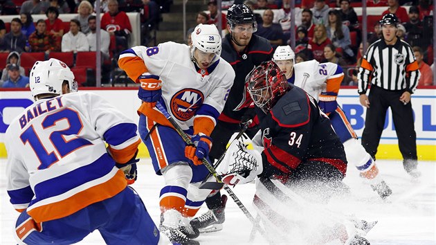 Brank Caroliny Petr Mrzek hled v nepehledn situaci puk, dotr na nj Michael Dal Colle z New York Islanders.