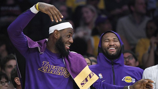LeBron James (vlevo) a DeMarcus Cousins vtipkují na lavičce LA Lakers.