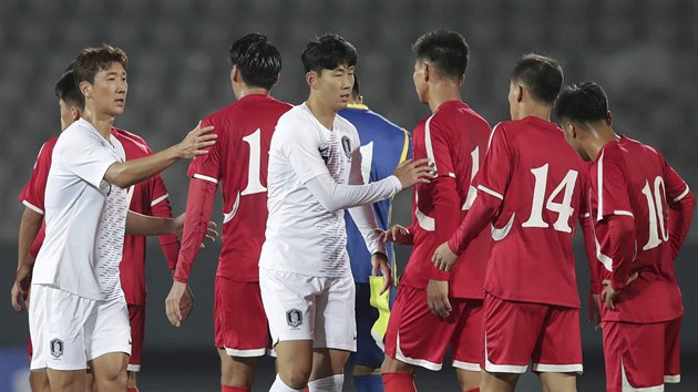 Jihokorej fotbalist (v blm) si podvaj ruce s reprezentanty KLDR po vzjemnm utkn kvalifikace o MS 2022.