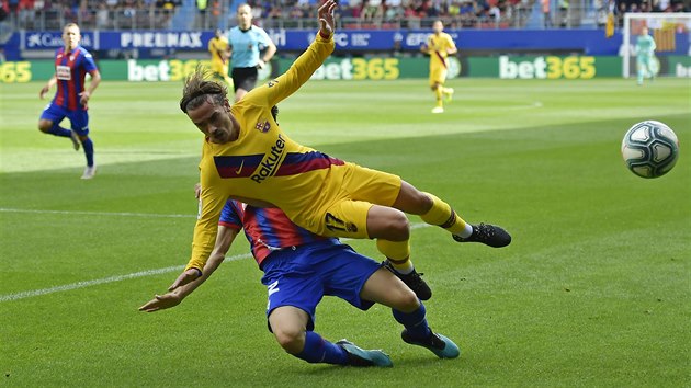 Barcelonsk forvard Antoine Griezmann pad v souboji s Paulo Oliveirou z Eibaru.