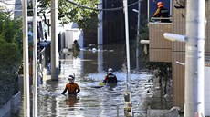 Japontí hasii prochází zaplavenou oblast v Tokiu. (13. íjna 2019)