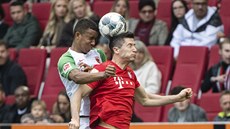 Felix Uduokhai z Augsburgu (vlevo) a Robert Lewandowski z Bayernu Mnichov v...