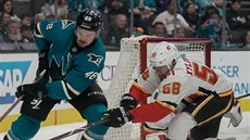 Tomá Hertl (vlevo) ze San Jose se vyhýbá Oliveru Kylingtonovi z Calgary.