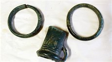 Bronzový poklad z Královédvorska tvoří dva zdobené náramky a polovina sekery s...