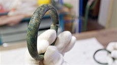 Bronzový poklad z Královédvorska tvoří dva zdobené náramky a polovina sekery s...
