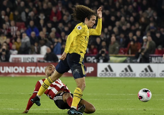 FAUL.Matteo Guendouzi z Arsenalu padá po skluzu Davida McGoldricka z Sheffieldu...