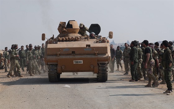 Tureckem podporovaní syrtí rebelové se shromaují kolem obrnného vozidla u...