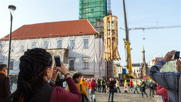 Vyzvedvn trnct metr vysokho a devt a pl tuny tkho kusu nov pice opravovan radnin ve v Olomouci na Hornm nmst. (23. jna 2019)