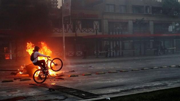 Cyklista projd kolem ohn v chilsk metropoli Santiago. (19. jna 2019)