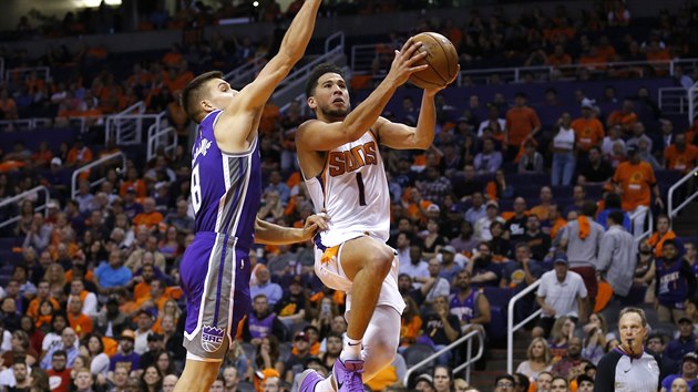 Devin Booker (vlevo) z Phoenixu zakonuje pes brncho Bogdana Bogdanovie ze Sacramenta.