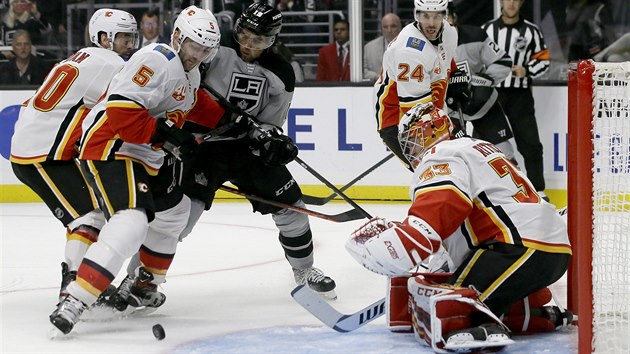 David Rittich v brance Calgary pozorn sleduje puk, zakonit se sna Alex Iafallo z Los Angeles.