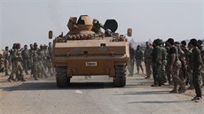 Tureckem podporovaní syrští rebelové se shromažďují kolem obrněného vozidla u...