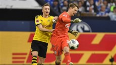 Marco Reus z Dortmundu (vlevo) napadá gólmana Schalke Alexandera Nübela.