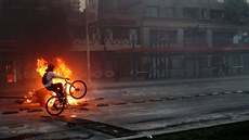 Cyklista projídí kolem ohn v chilské metropoli Santiago. (19. íjna 2019)
