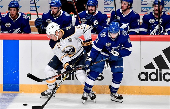 Kyle Okposo z Buffala (vlevo) bojuje u mantinelu s Braydenem Pointem z Tampy v...