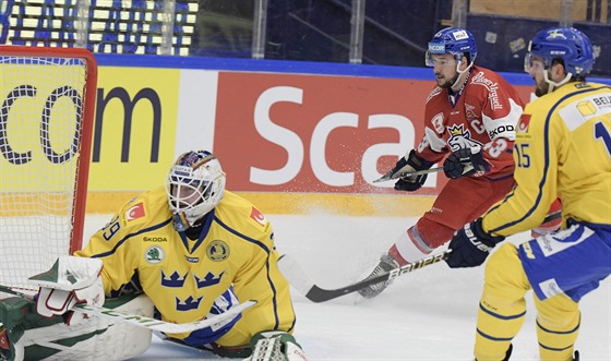 Jan Kovář (v červeném) překonává švédského brankáře Adama Reideborna.