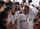 Kolegové z Mercedesu gratulují jezdci Lewisu Hamiltonovi (vpravo) k zisku...