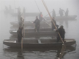 Rybáři postupně zatahují síť.