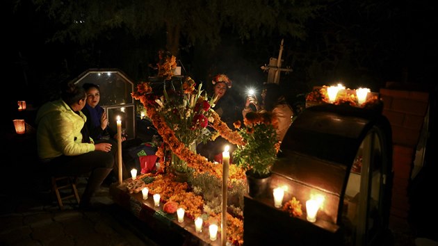 Pbuzn trv noc vedle hrobky svch blzkch na hbitov v Los Reyes bhem slavnost v Mexico City (1. 11. 2019).