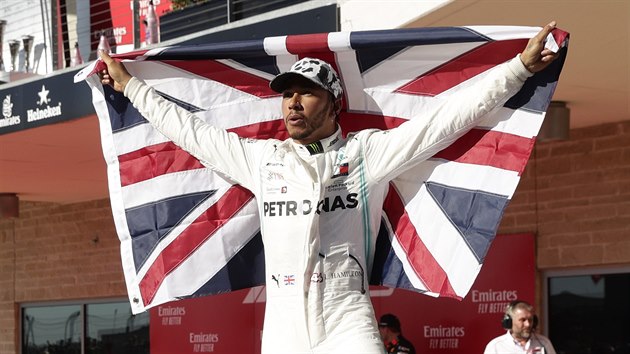Jezdec Mercedesu Lewis Hamilton slaví s britskou vlajkou po Velké ceně USA, ve které definitivně rozhodl o svém titulu.