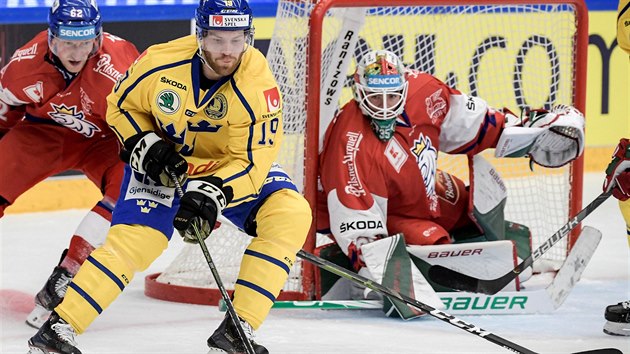 Švédský hokejista Oscar Lindberg se snaží natlačit před českého gólmana Romana Willa.  Brání ho Andrej Šustr.