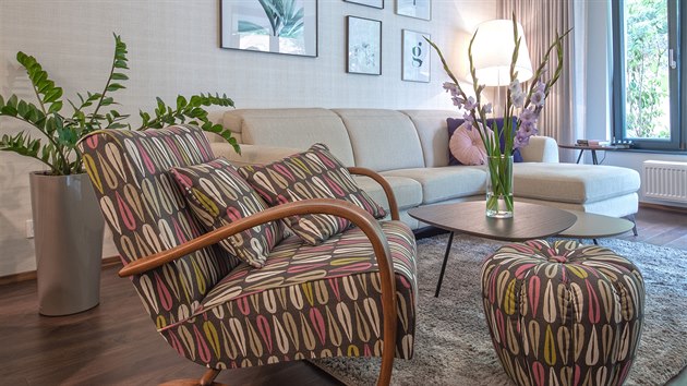 Krásným prvkem v bytě je repasované křeslo s podnožkou Halabala H269 s polstrováním v odstínech šedohnědé, růžovofialové a zelenožluté. 