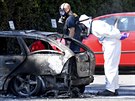 Švédští kriminalisté ohledávají vrak ohořelého automobilu v Malmö, kde byla...