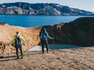 Turisté stojí nad kráterem islandské sopky Askja.