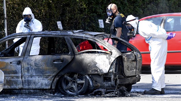 Švédští kriminalisté ohledávají vrak ohořelého automobilu v Malmö, kde byla zavražděna přibližně třicetiletá žena. (26. srpna 2019)