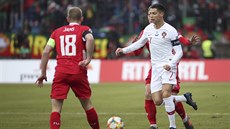 Portugalec Cristiano Ronaldo (v bílém) vede balon mezi lucemburskými hrái...