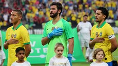 Brazil�tí fotbalisté Richarlison, Alisson a Marquinhos (zleva) zpívají p�i...