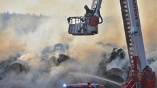 Hasiči bojují s požárem stohu slámy v Tymákově na Plzeňsku. Na pomoc si...