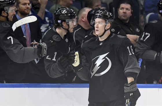 Ondej Palát sbírá gratulace ke gólu od parák z Tampa Bay Lightning.