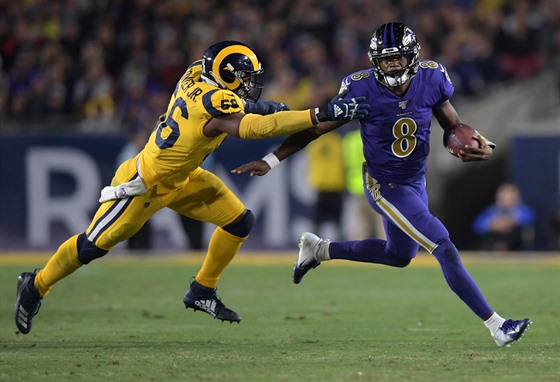 Lamar Jackson (8) z Baltimore Ravens nahánný Dantem Fowlerem z Los Angeles...