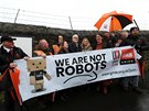 „Nejsme roboti,“ hlásá transparent, který v rukou drží zaměstnanci Amazonu v...