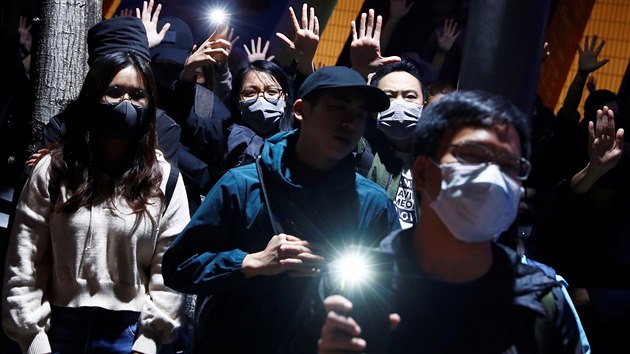 Protestujc zvedaj ruce, aby symbolizovali 5 poadavk protivldnho protestnho hnut, kdy kieli slogany bhem shromdn proti hromadnmu sthn v Tsim Sha Tsui v Hongkongu. (28. listopadu 2019)