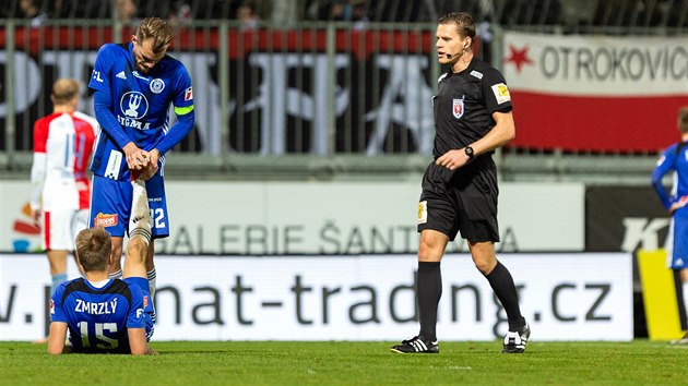 Rozhod Pavel Rejek bhem utkn Olomouc - Slavia sleduje, jak Vt Bene (vlevo) pomh  spoluhri Ondeji Zmrzlmu.