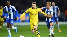 Marco Reus (ve lutém) z Dortmundu vede balon, stíhá jej Per Ciljan Skjelbred z...