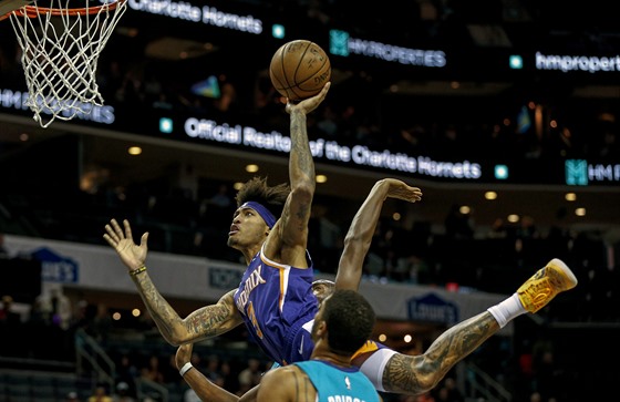 Kelly Oubre Jr. (vlevo) z Phoenixu zakonuje pes Milese Bridgese z Charlotte.