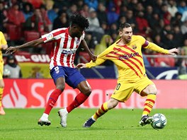 Lionel Messi z Barcelony (vpravo) běží s balonem, brání jej Thomas Partey z...