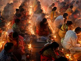 Hindu devotees sit together on the floor  of a temple to observe Rakher...