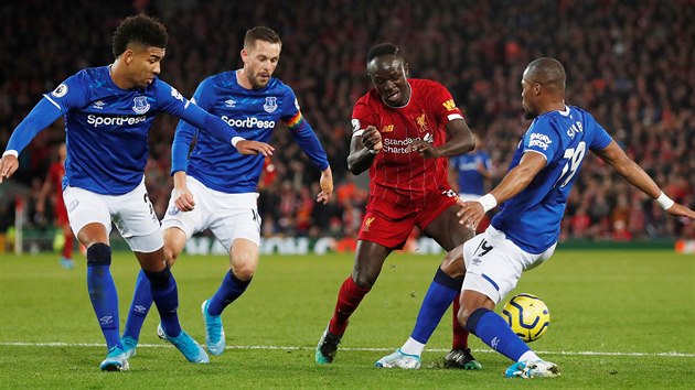 Sadio Mané z Liverpoolu se prodírá mezi třemi soupeři Evertonu.