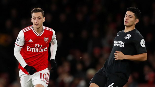 Mesut Özil (vlevo) z Arsenalu sleduje míč odehraný Stevenem Alzatem z Brightonu.