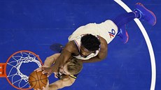 Domantas Sabonis (vlevo) z Indiany smeuje na ko Philadelphie, Joel Embiid...