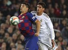 Luis Suárez (vlevo) zpracovává mí, brání ho Raphael Varane.