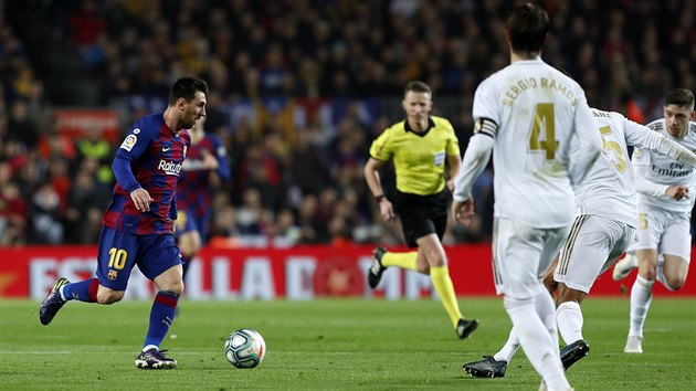 Lionel Messi má míč pod kontrolou a vyráží proti soupeřům z Realu Madrid.