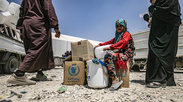 Dvka sed vedle balk humanitrn pomoci v tboe Al-Hl. (22. ervence 2019)