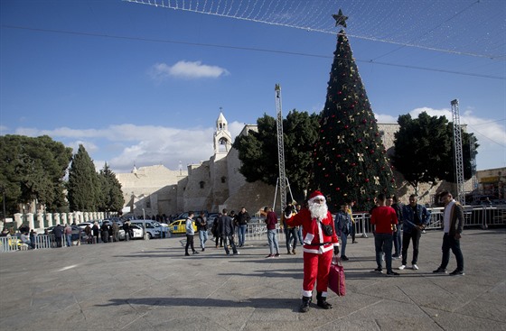 Palestinec v kostýmu Santa Klause vítá kesanské návtvníky ped kostelem...