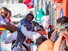 Migranti zadrení u pobeí ostrova Gran Canaria nastupují na panlskou...