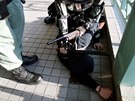 Policista zatýká jednoho z demonstrant, kteí protestovali v nákupním...